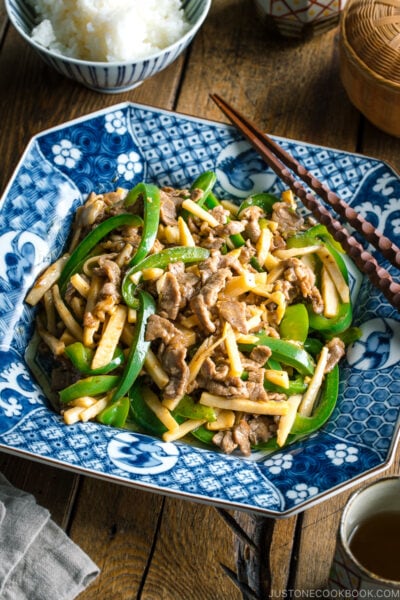 A Japanese blue and white ceramic containing Beef and Green Pepper Stir Fry.
