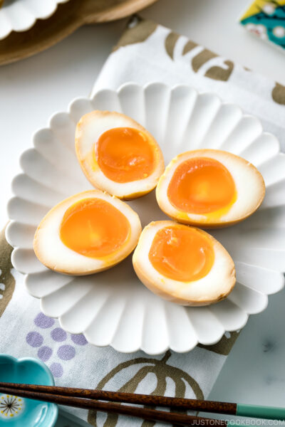 A white ceramic plate containing ramen eggs.