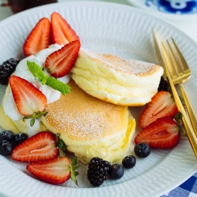 Japanese Souffle Pancakes with berries and fresh whipped cream.